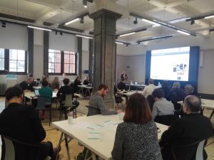 people sat at tables looking at a presentation